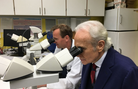 Josep Carreras mirando un microscopio en un laboratorio de investigación